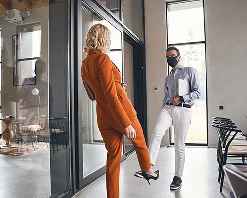 photo of employees wearing masks in an office practicing social distancing